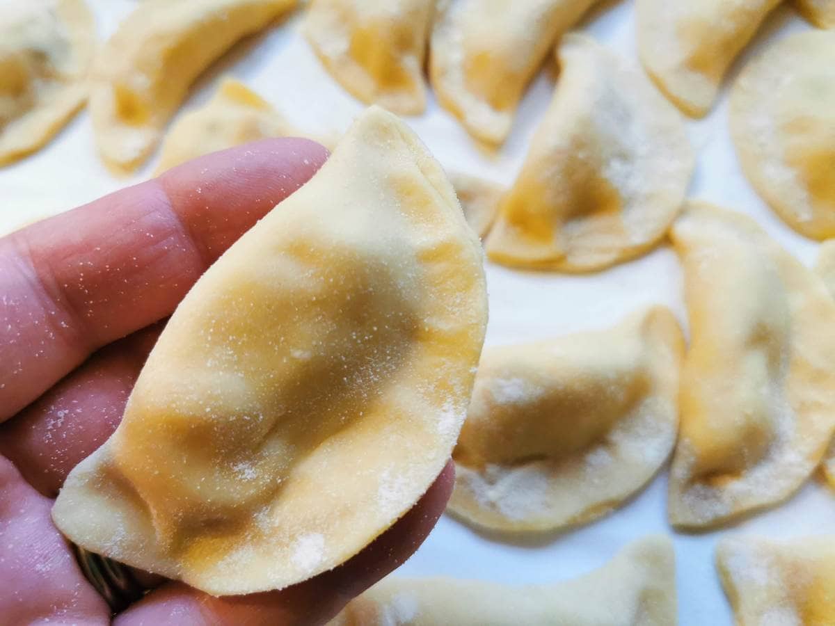 one ready potato and mint ravioli on a person's hand