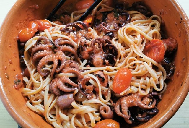 linguine and baby octopus alla Luciana in terracotta bowl