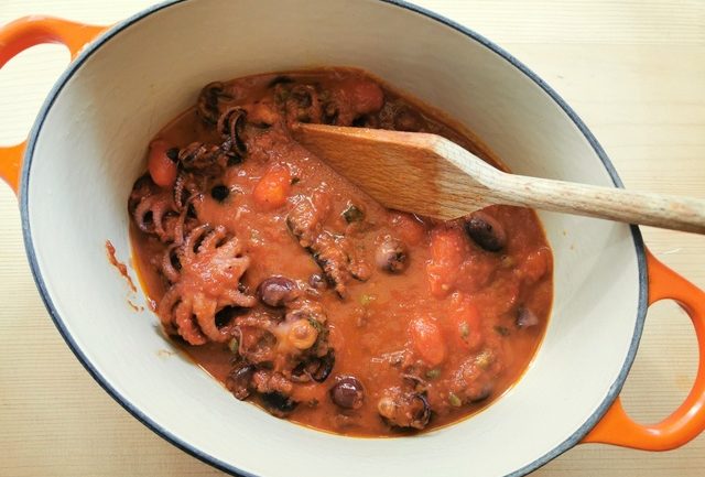 baby octopus in sauce cooking in Dutch oven