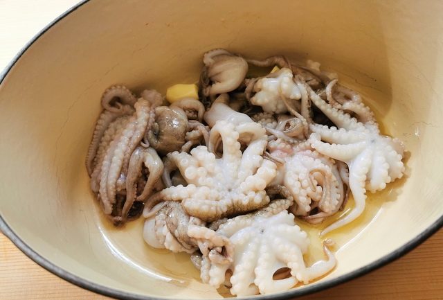 baby octopus cooking in Dutch oven with garlic