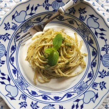 Mint pesto pasta in a bowl with mint leaves.