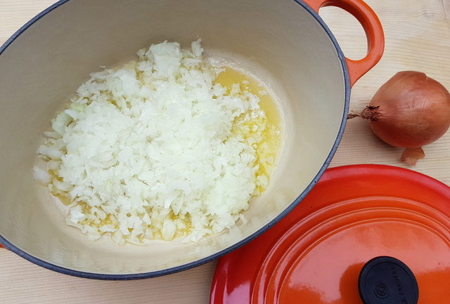 finely chopped onions cooking in Dutch oven with olive oil