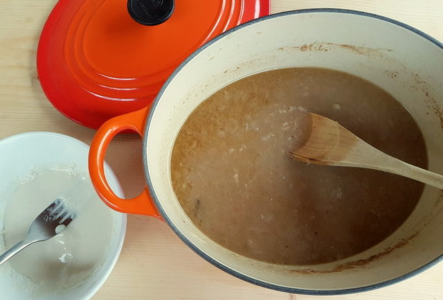 sauce for maltagliati pasta with braised veal and onions thickening in Dutch oven