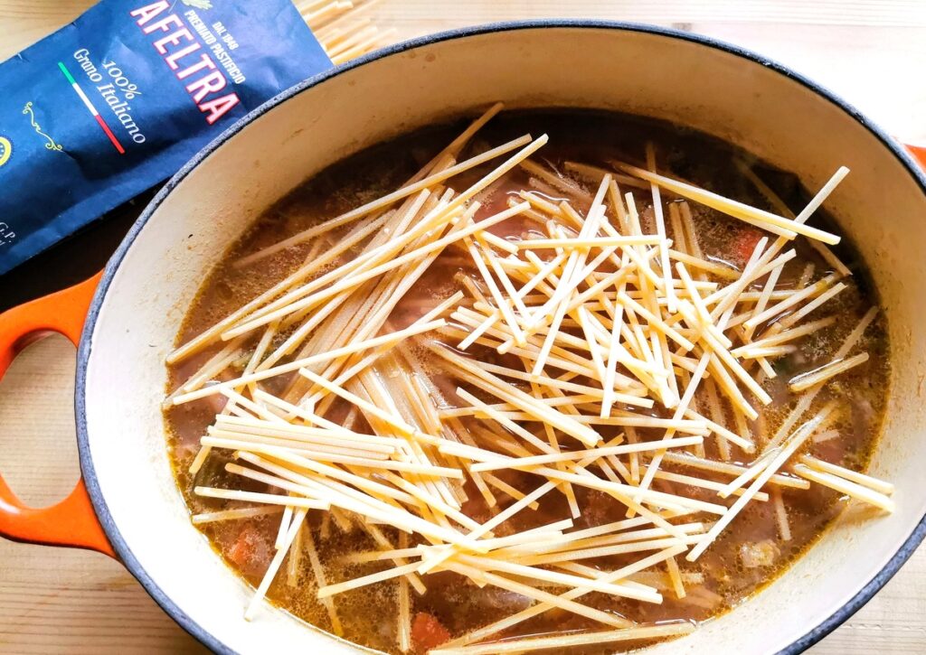 adding pasta to the minestrone