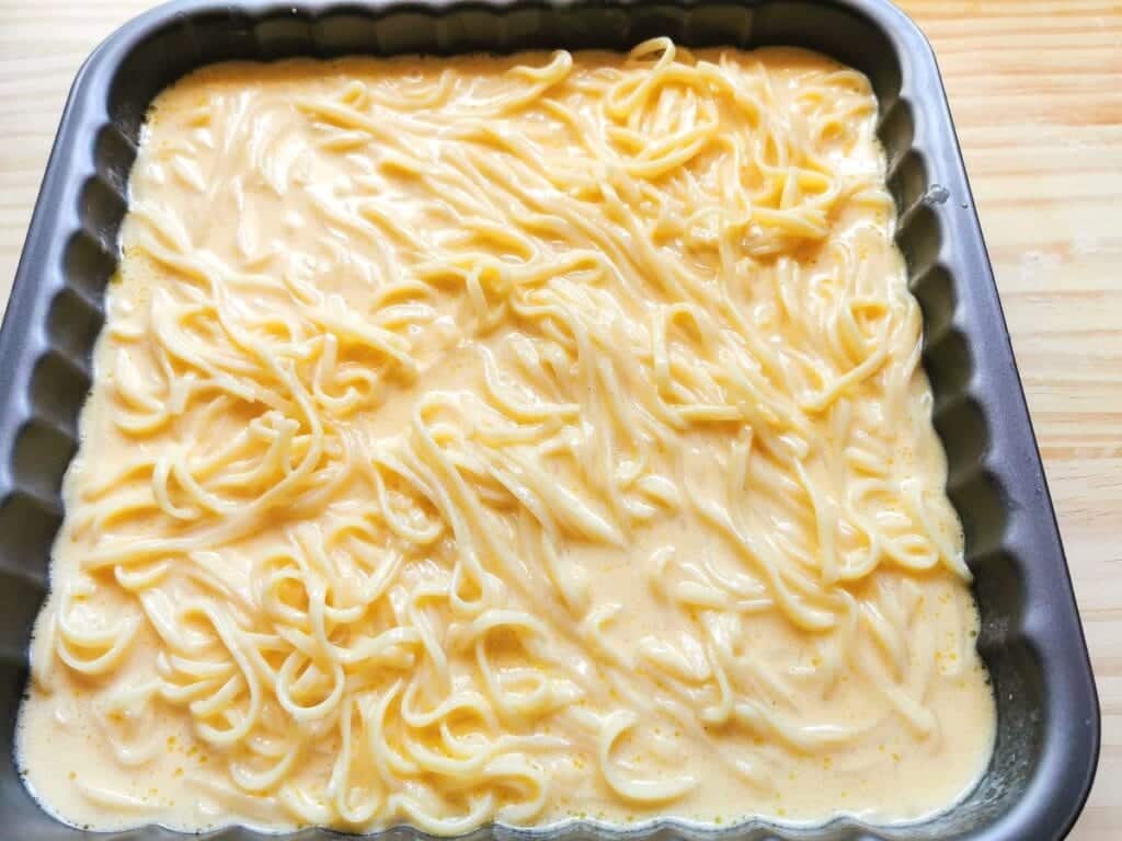 ricotta and pasta pie filling in square cake tin.