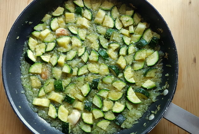 Zucchini, onions and garlic cooking in frying pan