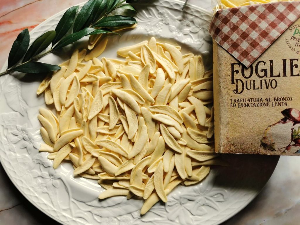 white olive leaf pasta on white plate.