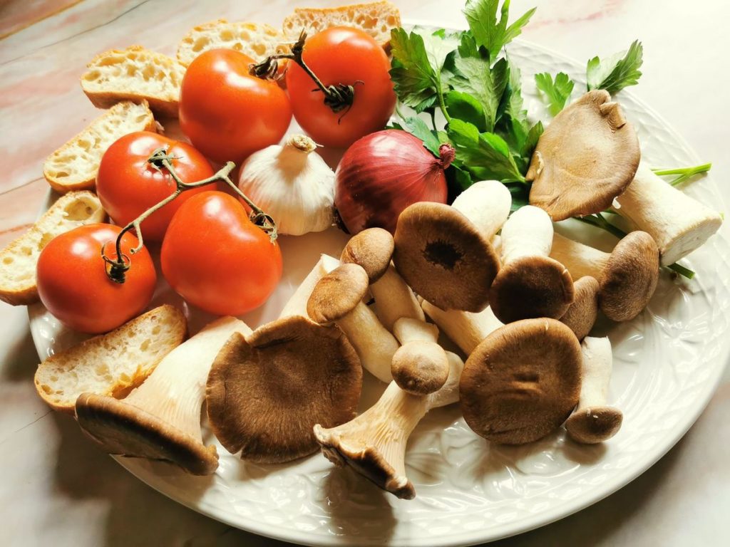 Ingredients for pasta with king oyster mushrooms on white plate