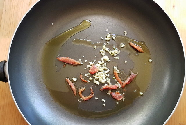 anchovie pieces and chopped garlic in frying pan