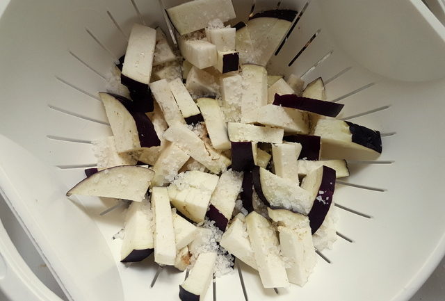 pieces of eggplant with salt in colander