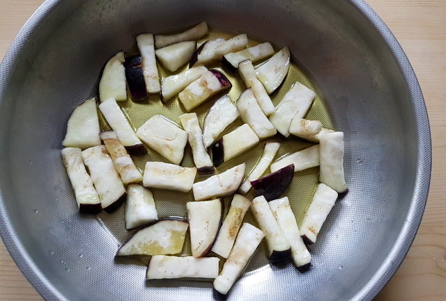 eggplant pieces cooking in oil in pan