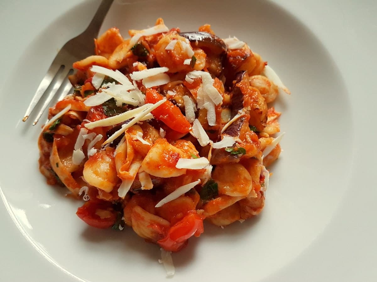 orecchiette with eggplant and nduja in white bowl.