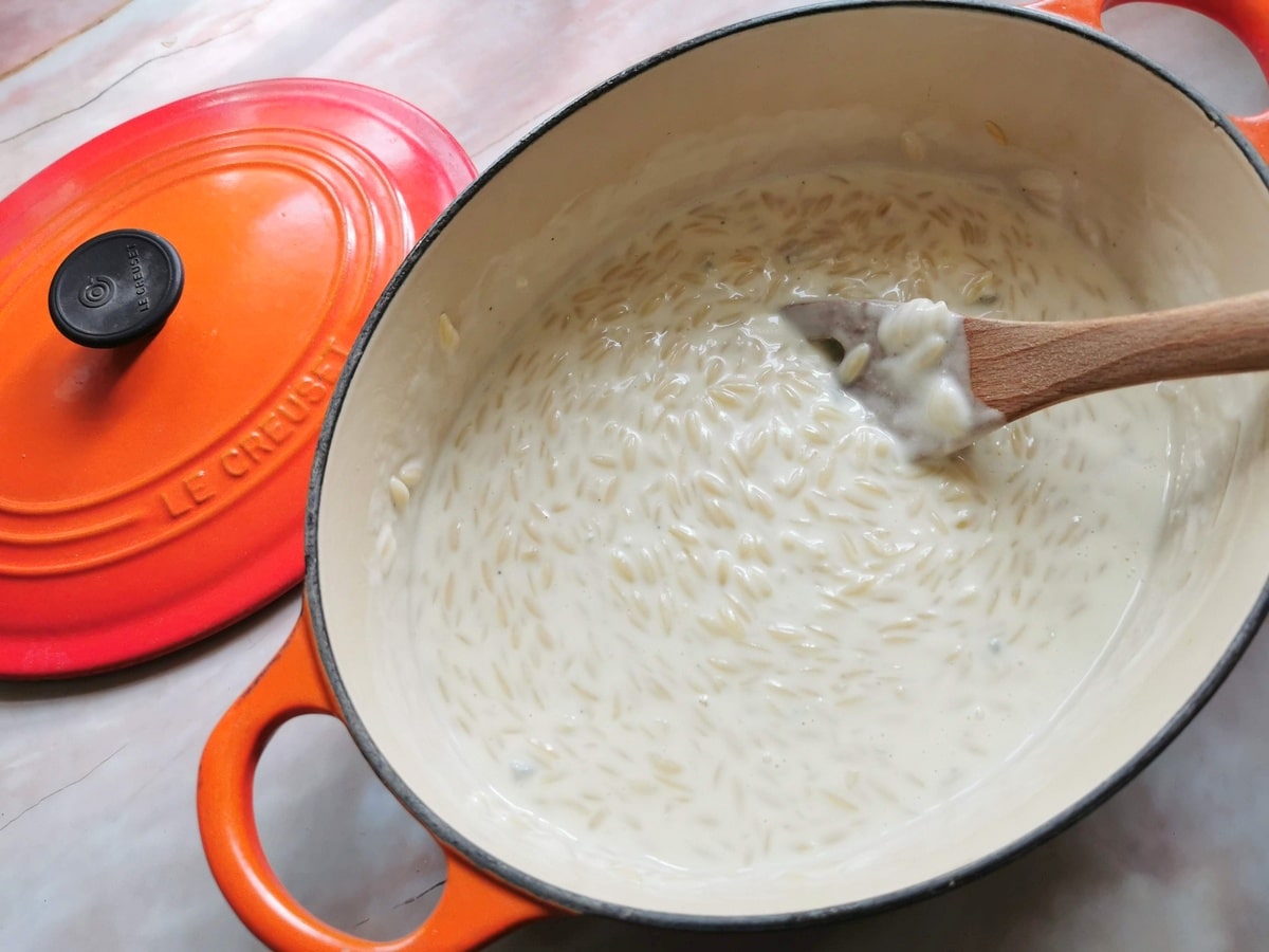 Orzo pasta risotto with gorgonzola cooking in Dutch oven.