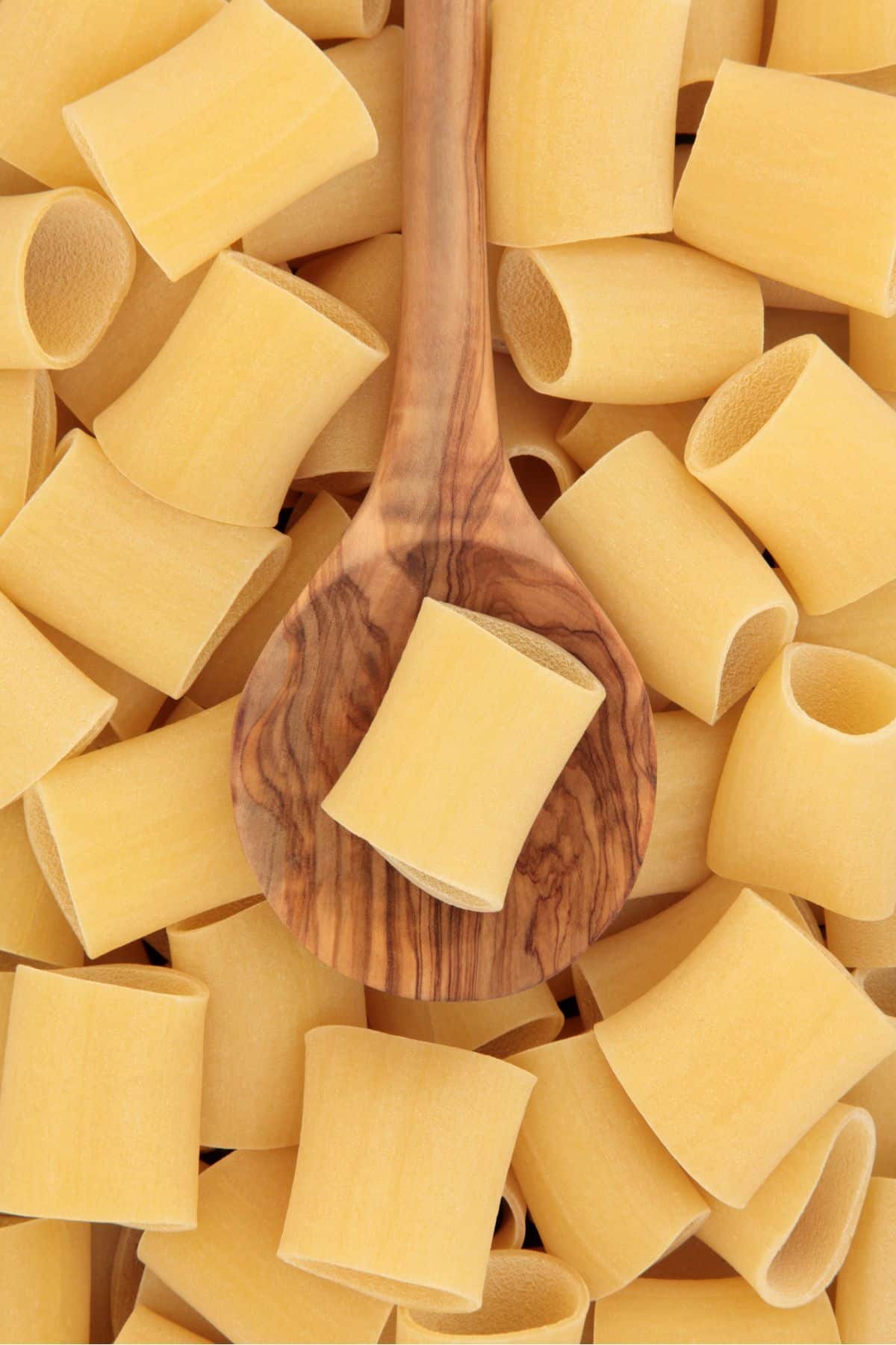 Paccheri size next to a wooden spoon.