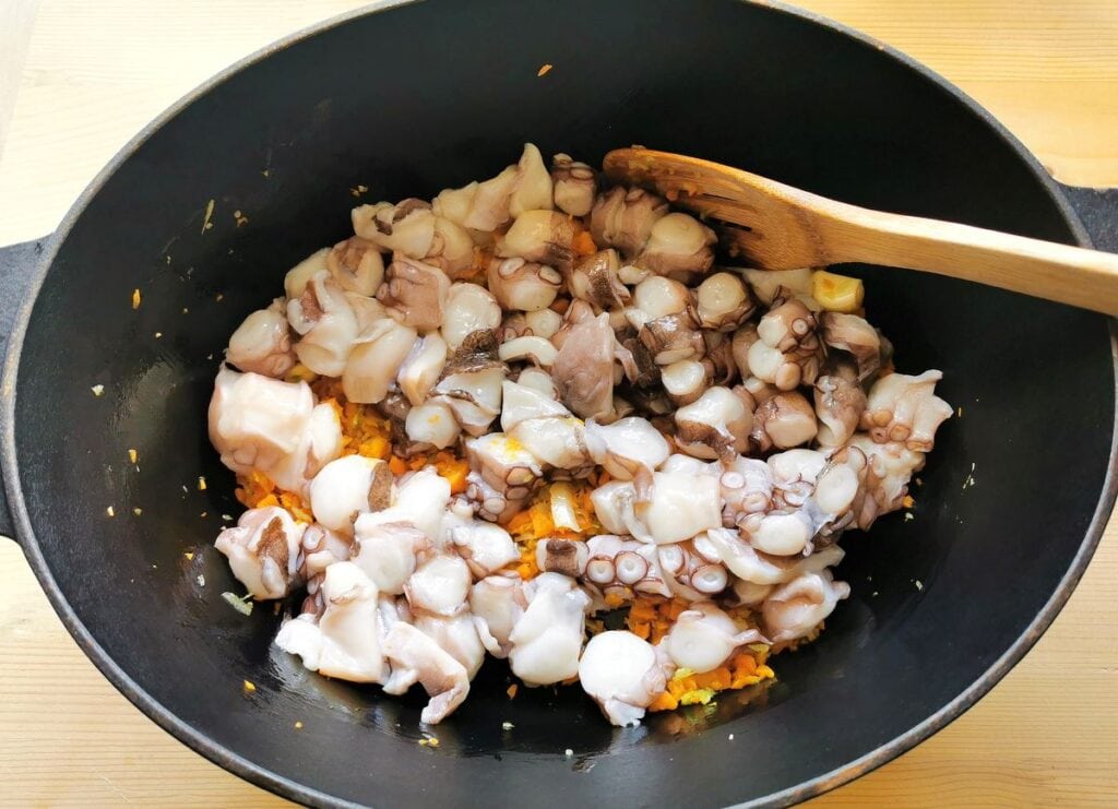 Octopus pieces in Dutch oven with carrots and celery