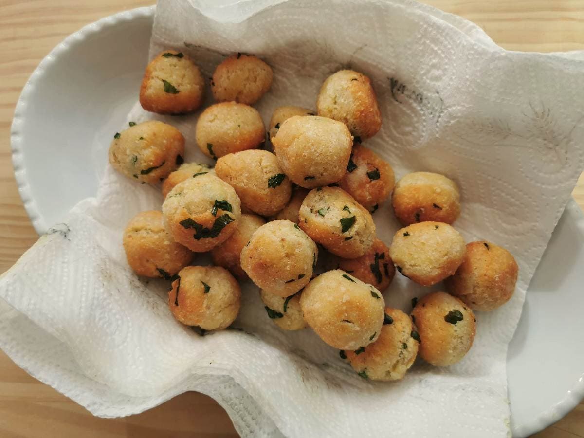 Ready pallotte on kitchen paper in white dish.
