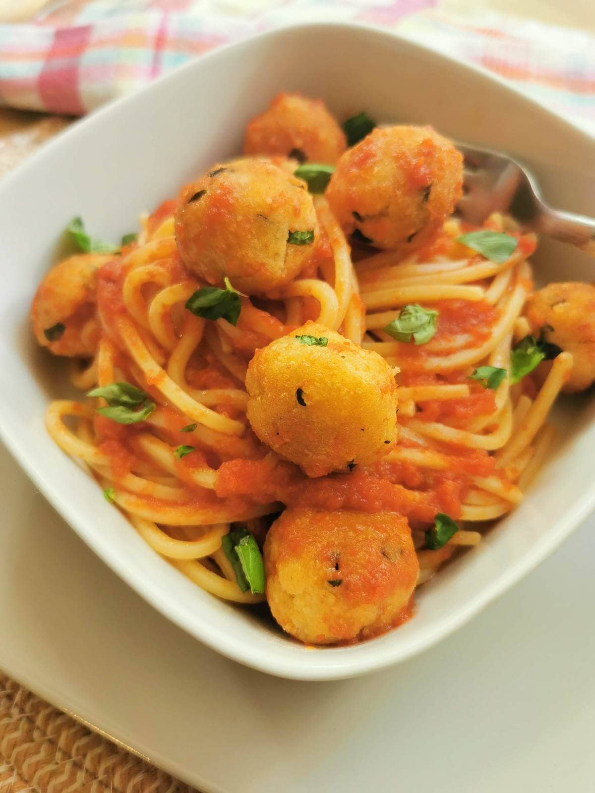 Italian cheese and egg balls in tomato sauce with spaghetti.