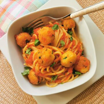 Pallotte cacio e ova in tomato sauce with pasta.