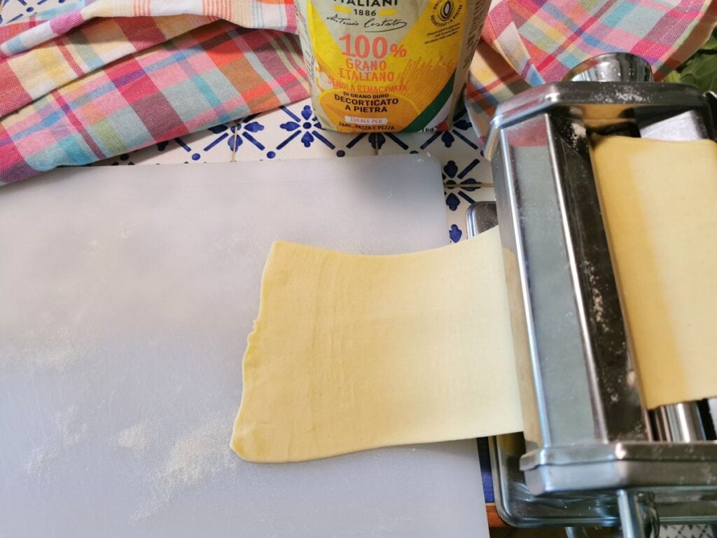 Pasta dough sheet passing through a pasta machine