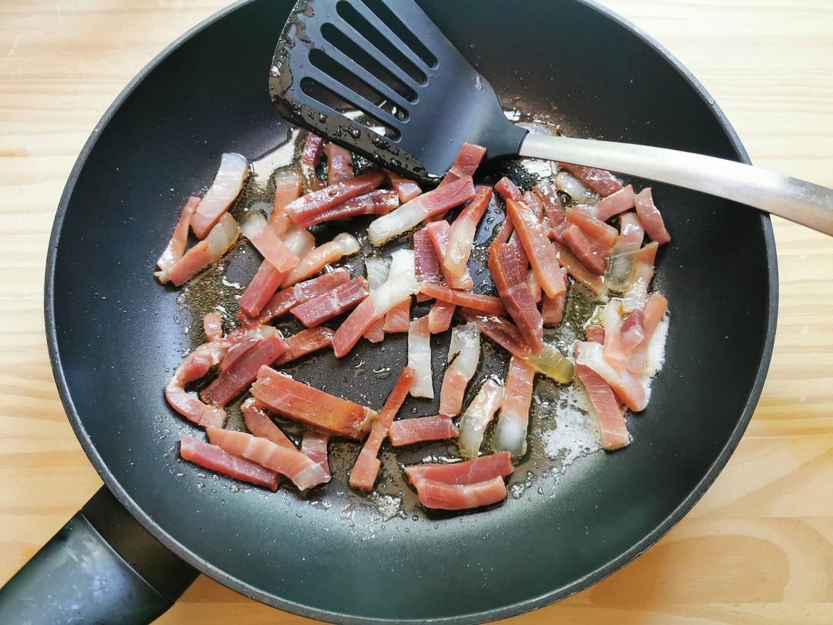 Culatello Prosciutto cut into strips and frying in skillet with butter.