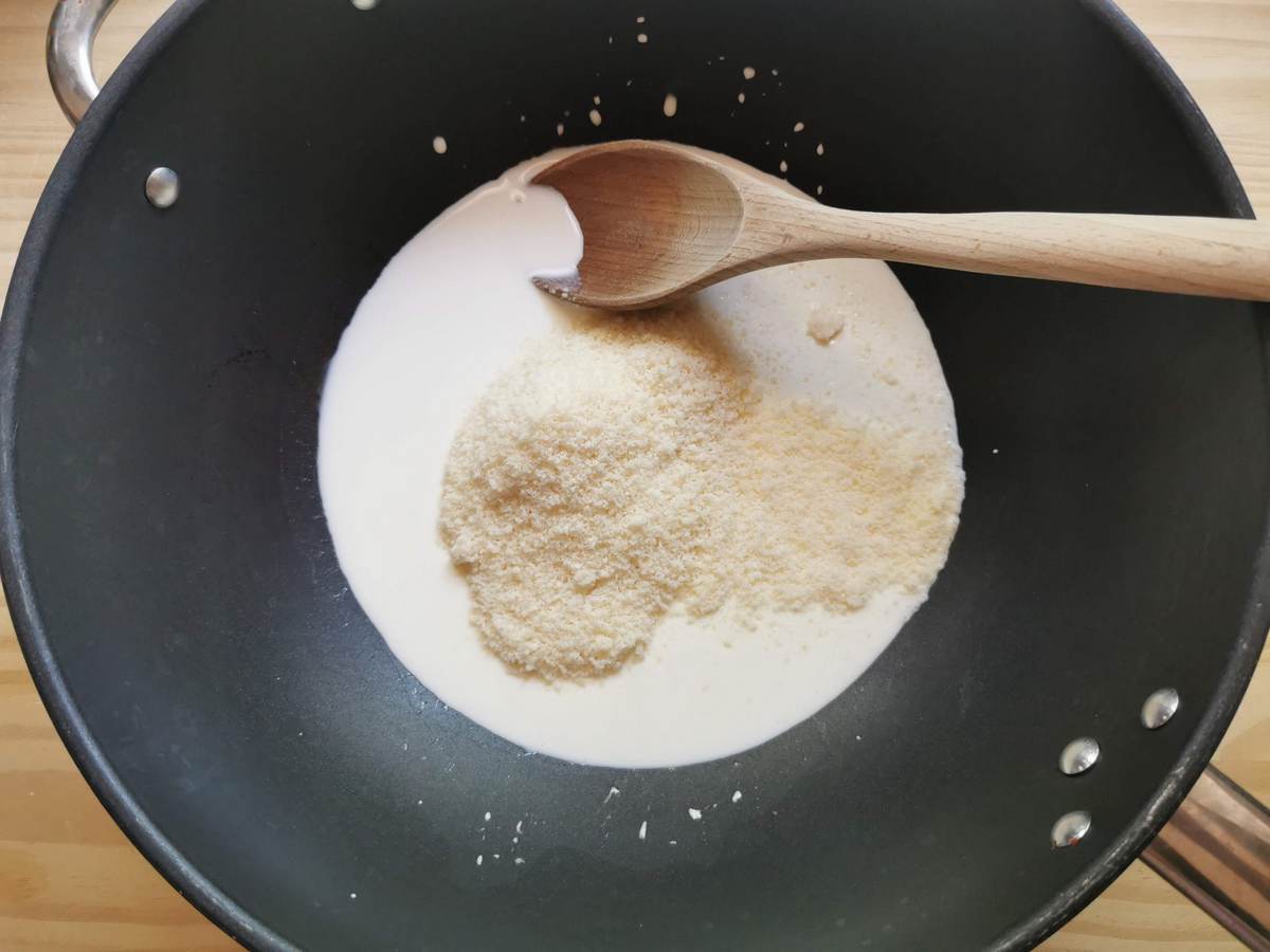 Grated Parmigiano in deep skillet with fresh cream.