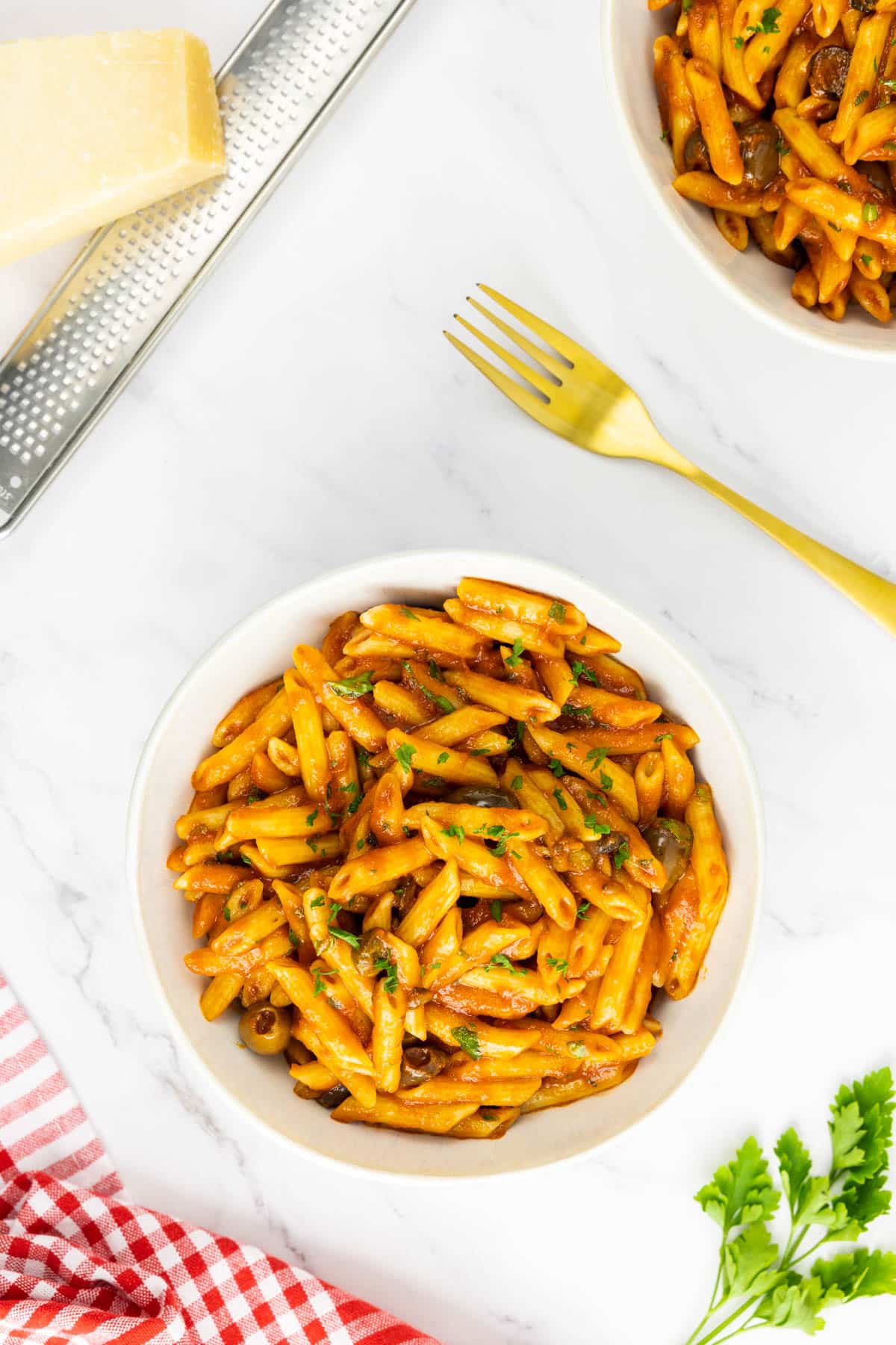 Two bowls of Mediterranean pasta with a fork