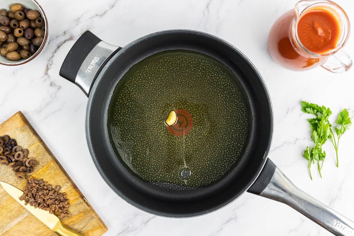 Garlic caramelizing in a pan with olive oil