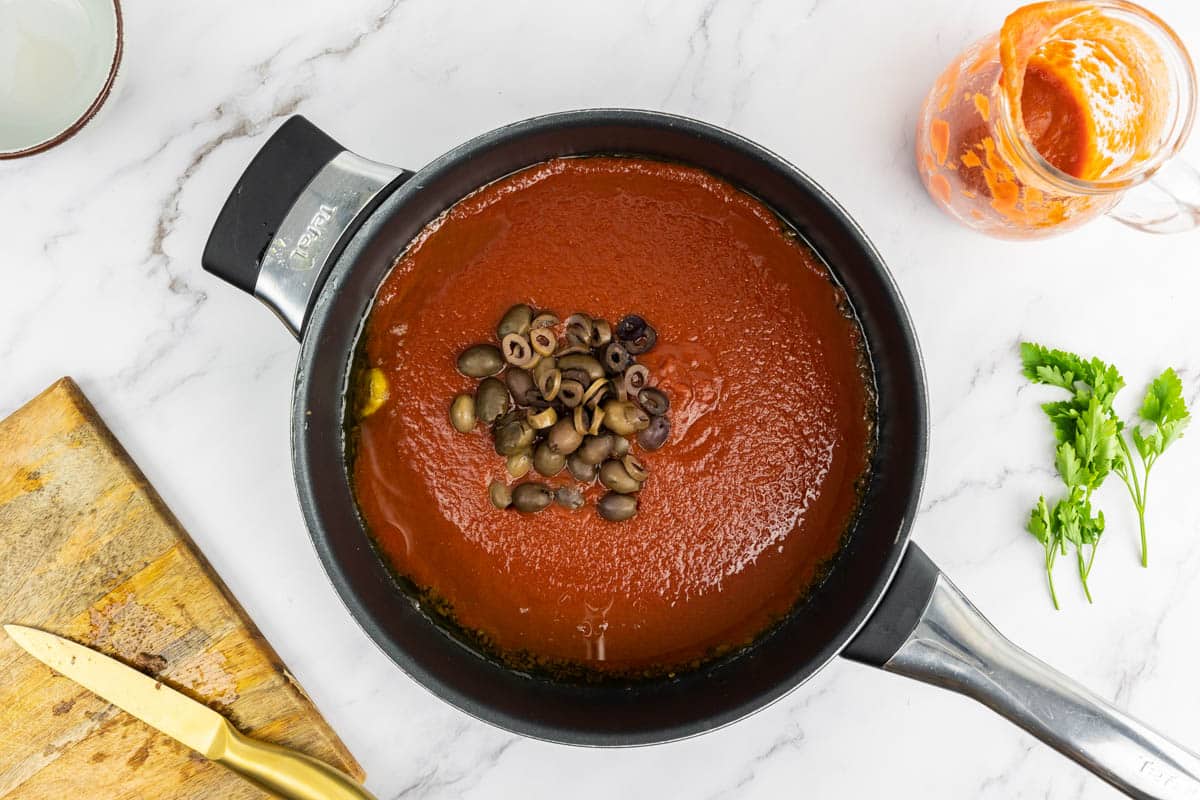 Tomato passata and olives added to the infused olive oil