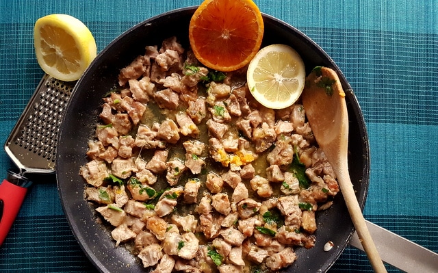 Pasta Ossobuco chopped veal in frying pan with orange and lemon slices