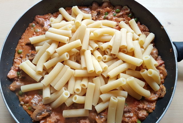 canneroni pasta tubes added to pasta sauce in frying pan
