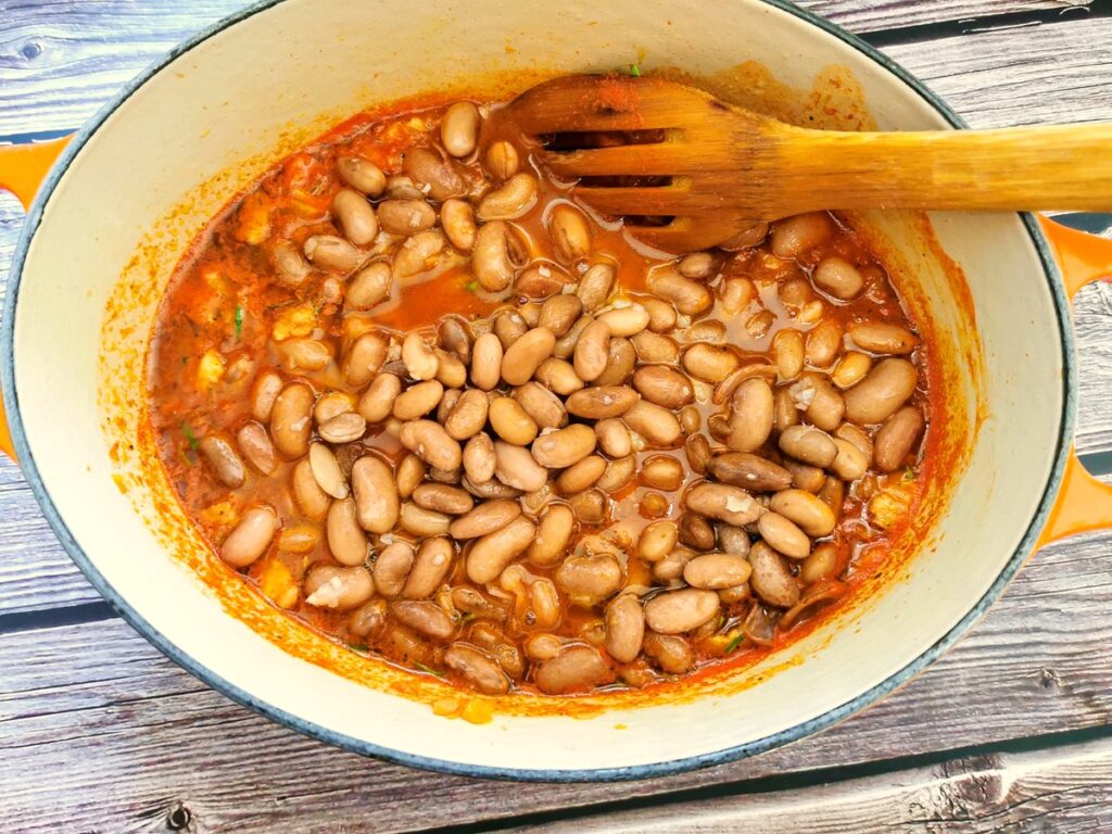 cooked beans added to other ingredients in Dutch oven 
