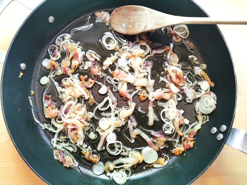 onions and lardo cooking in skillet