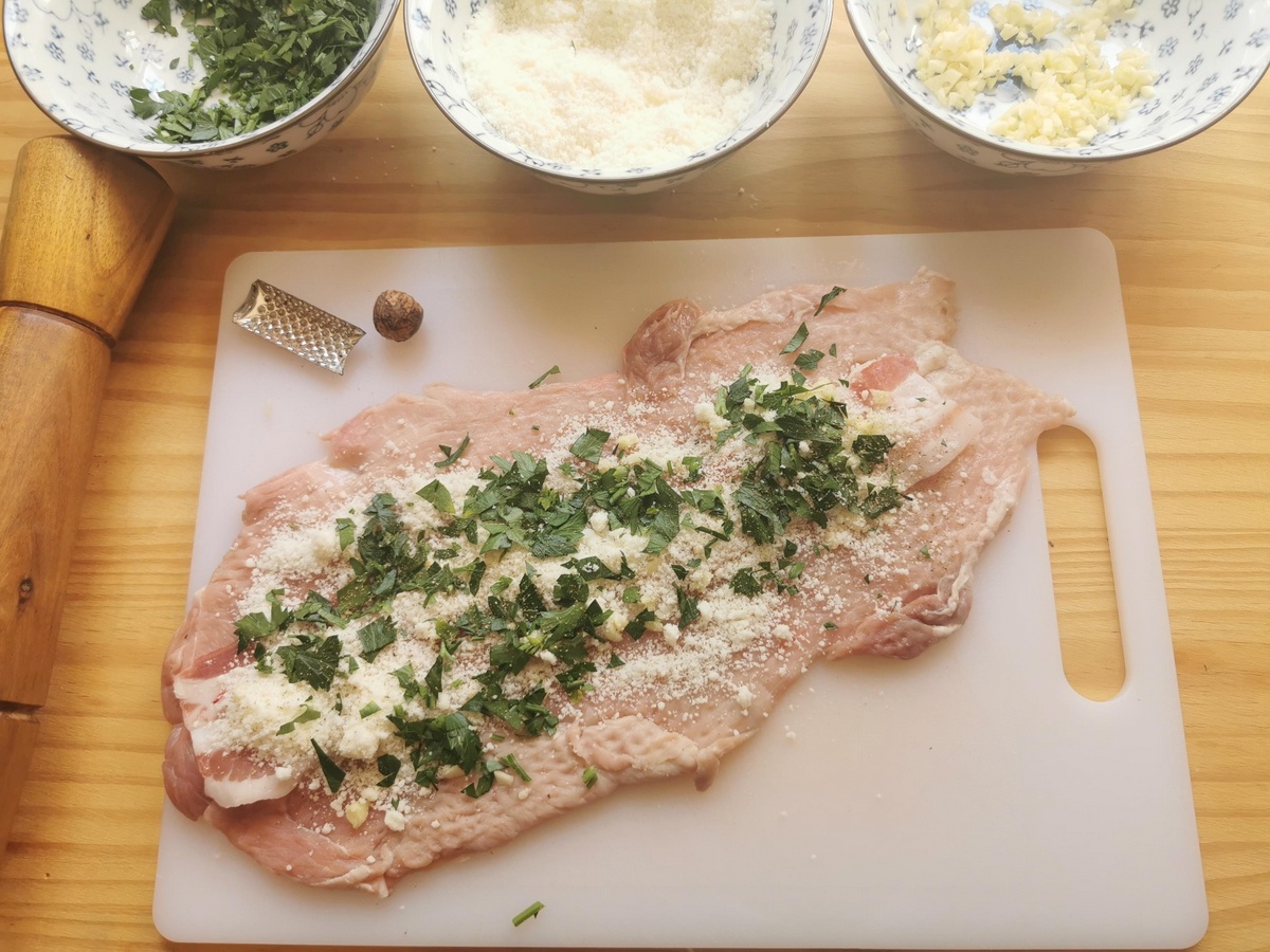 One slice of beaten pork shoulder with pancetta, fresh parsly, chopped garlic and grated pecorino and nutmeg on top.