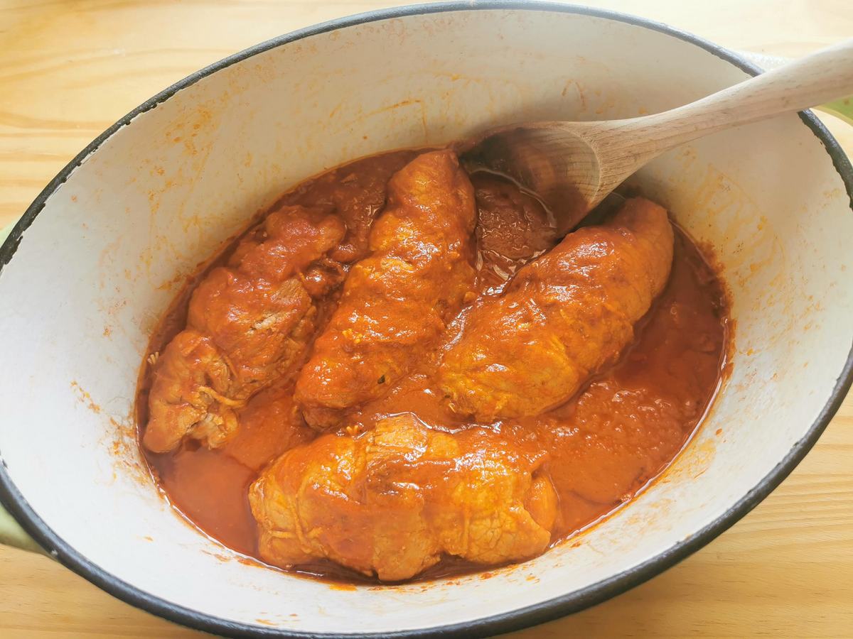 4 cooked pork involtini in tomato sauce in Dutch oven.