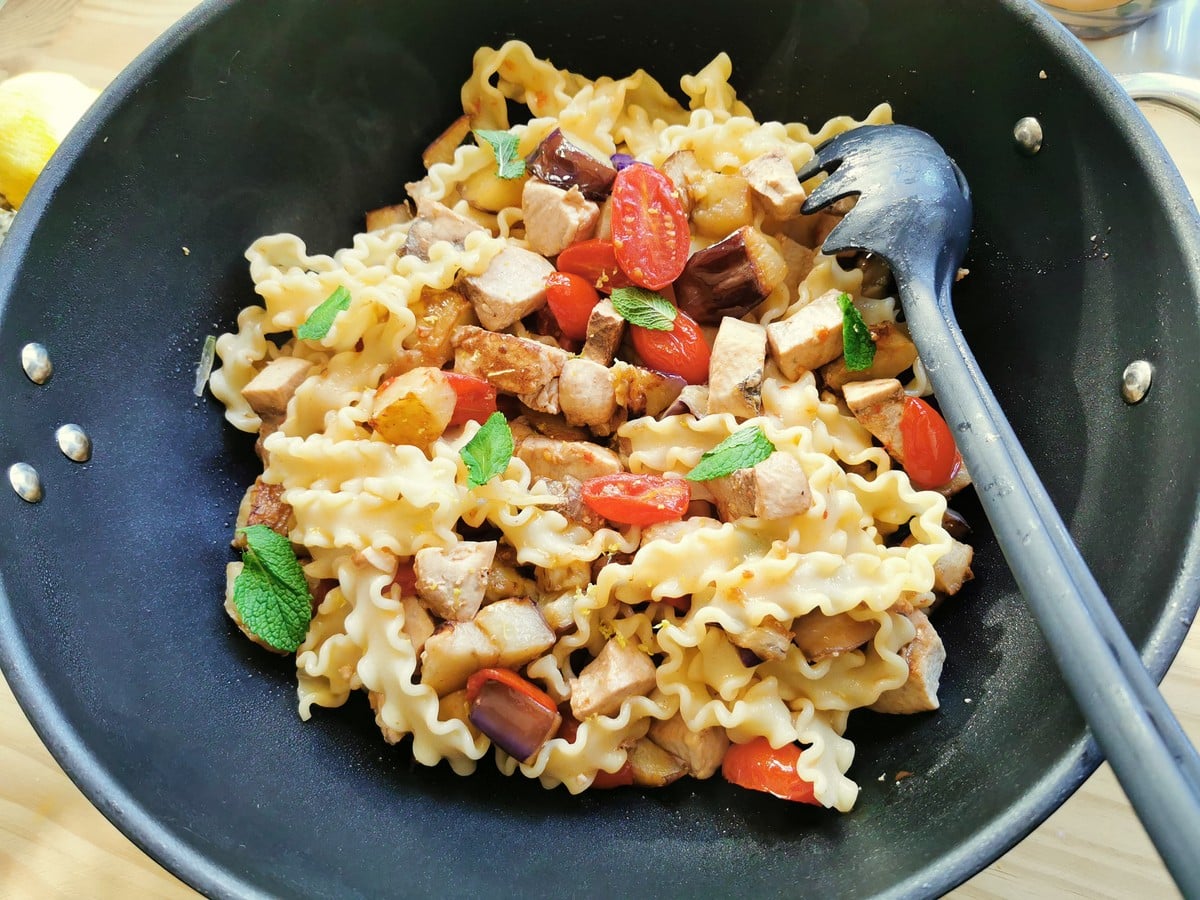 Adding pasta to the swordfish and vegetable mixture.