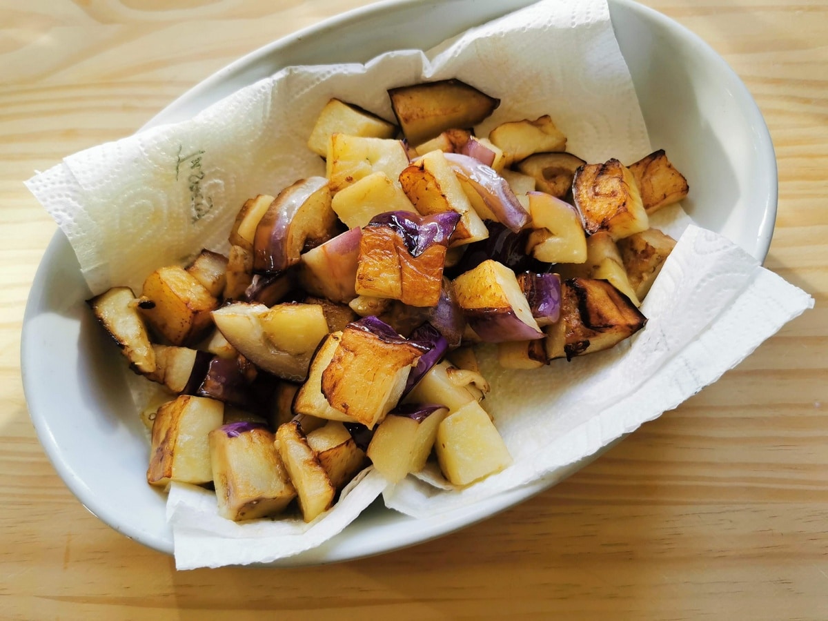 Fried eggplant draining on paper towels.