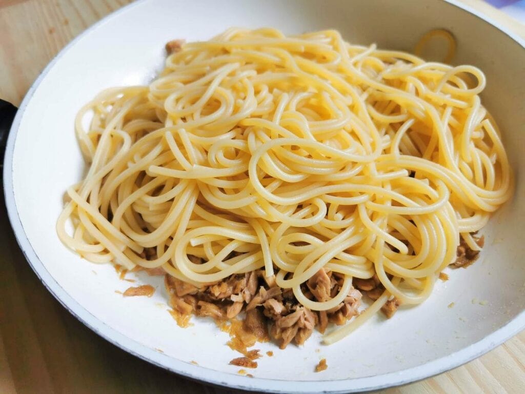 cooked and drained spaghetti in pan with tuna