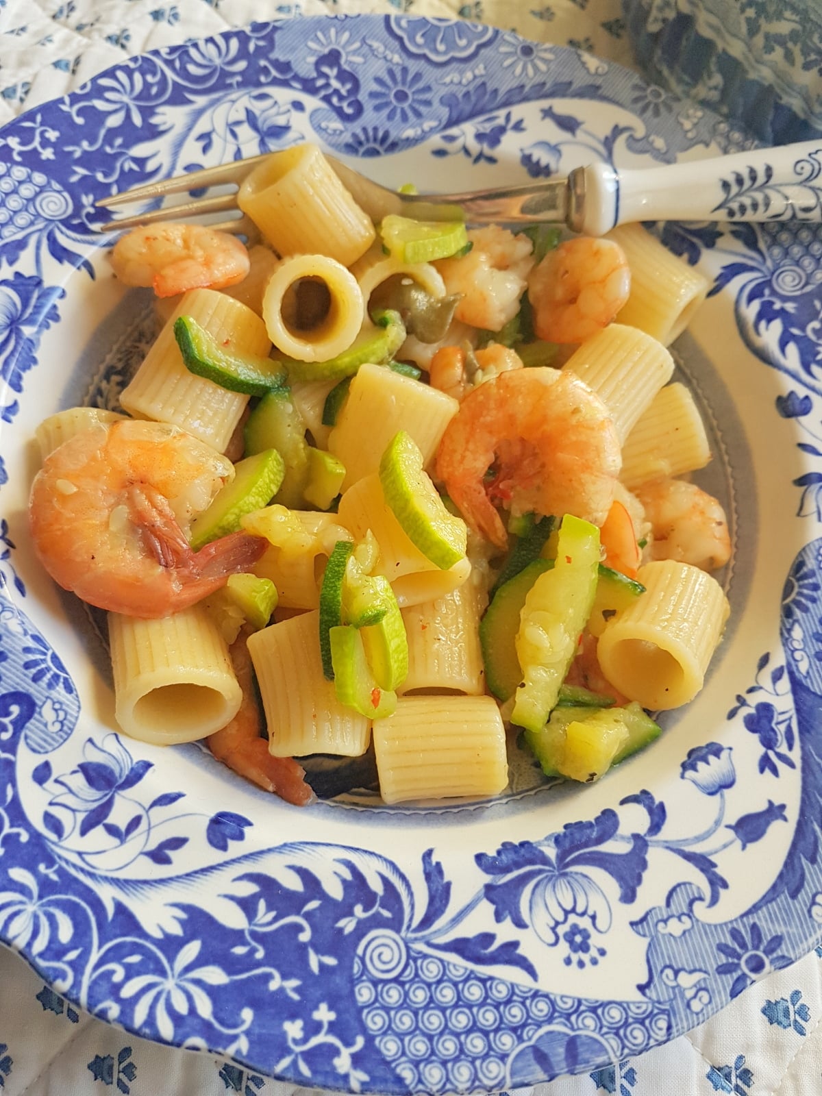 Pasta with zucchini and shrimp in a bowl.