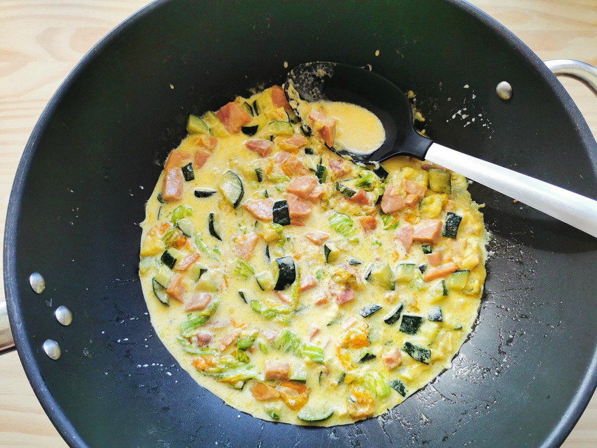 Zucchini flower, saffron and ham pasta sauce in deep skillet.
