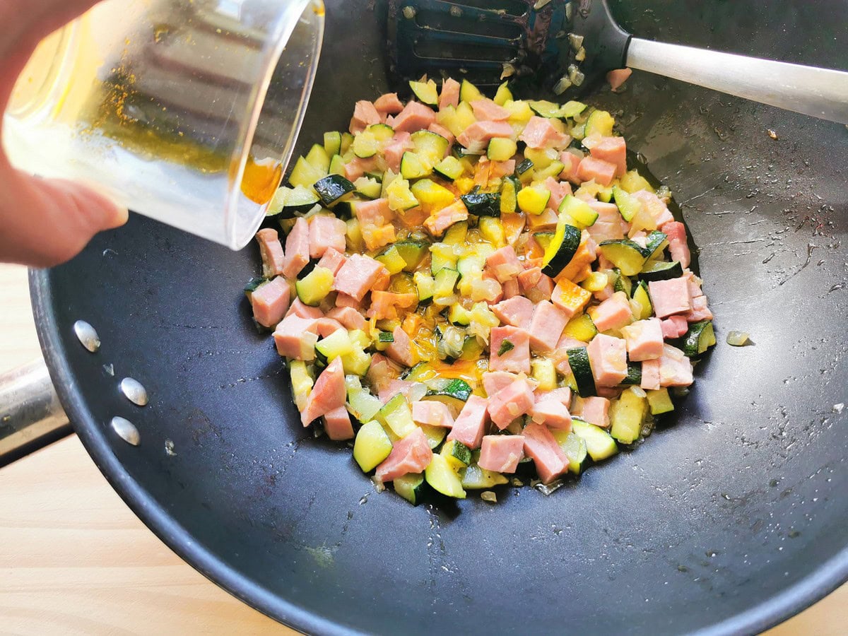 Saffron dissolved in water added to skillet with ham, zucchini and onion.