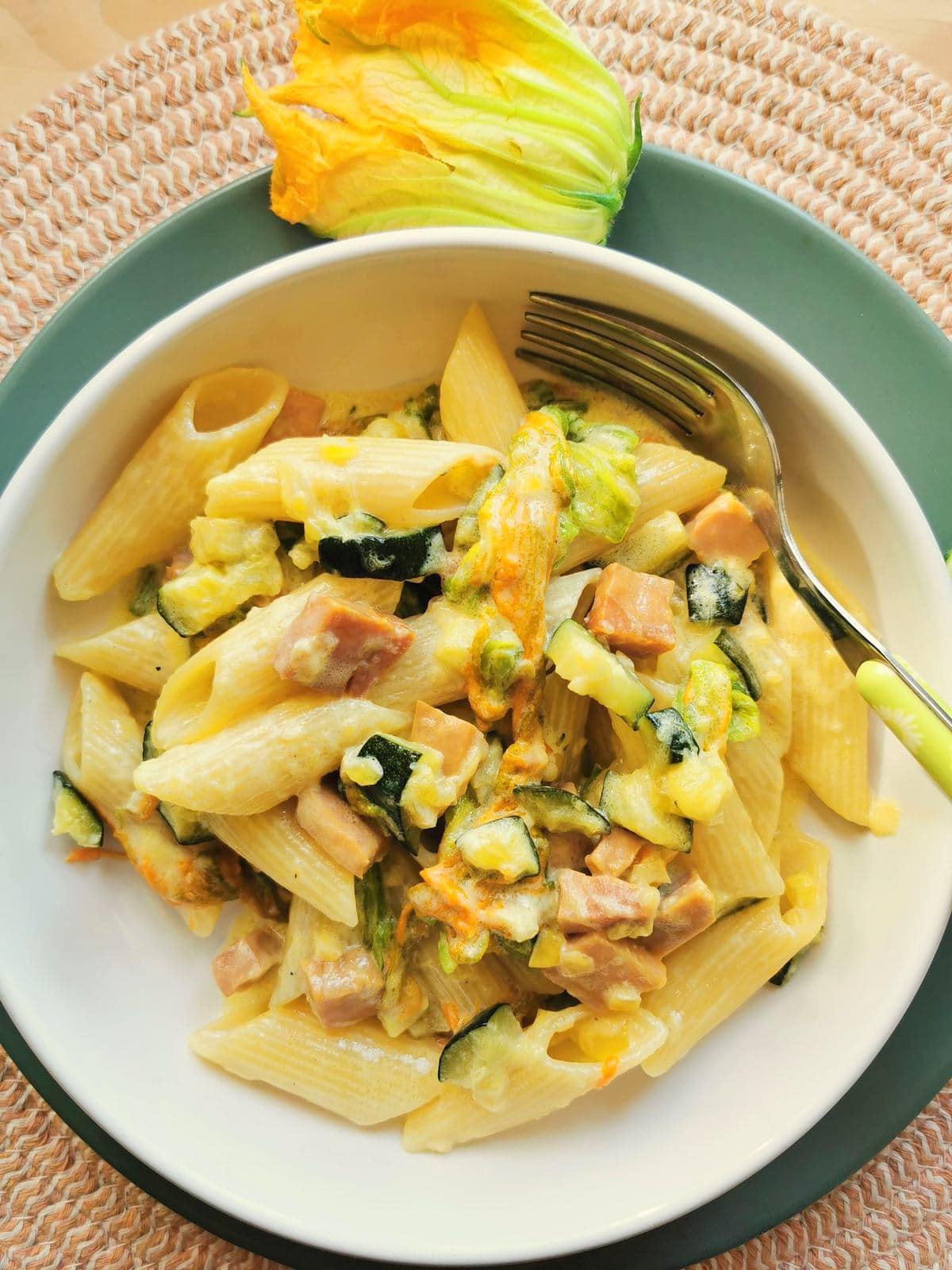 Creamy pasta with zucchini flowers, saffron and ham.