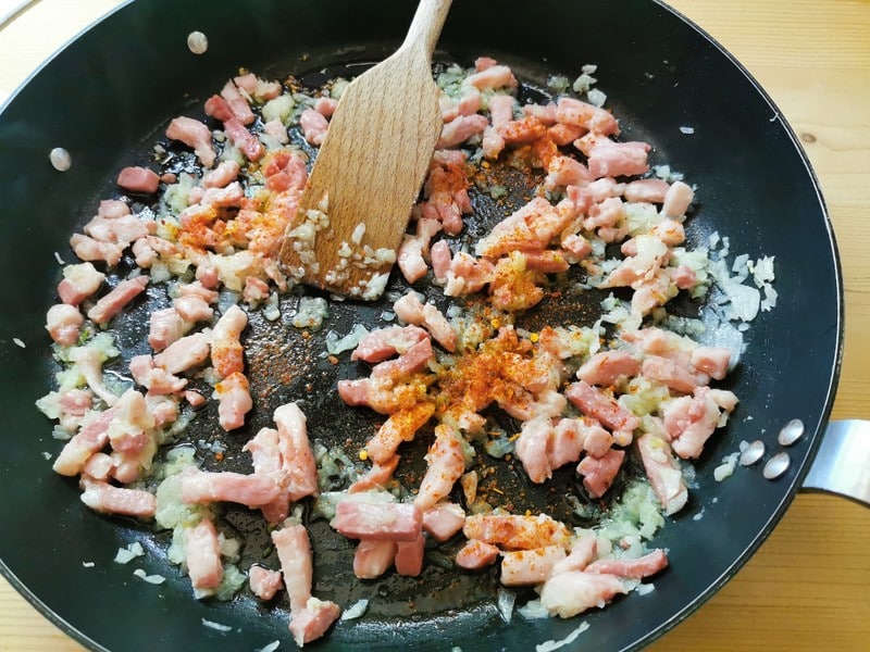 onion, pancetta and peperoncino cooking in skillet