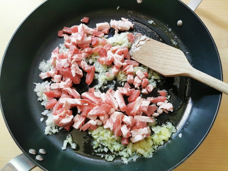 chopped onion and diced pancetta frying in skillet