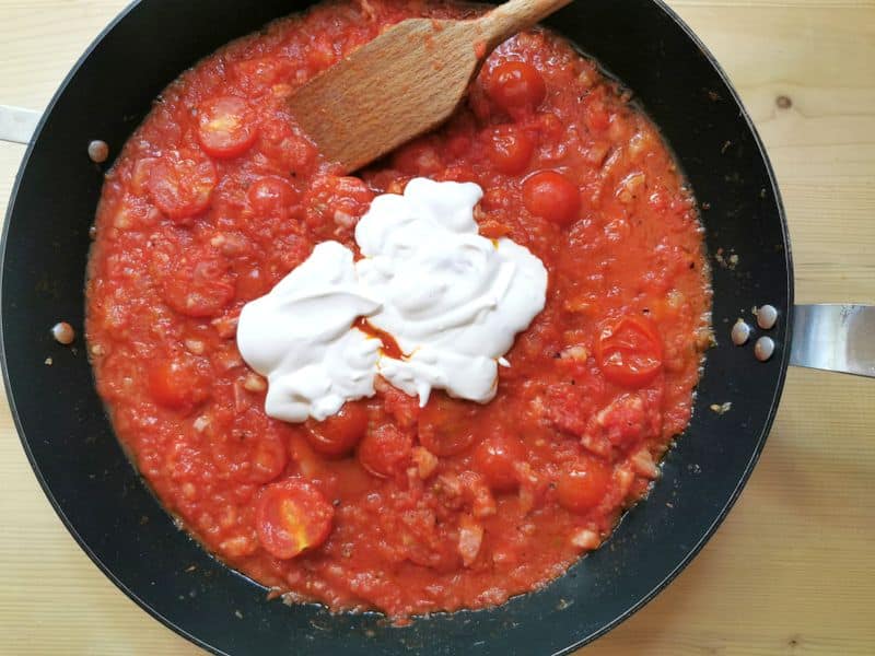 cream added to vodka tomato sauce in skillet