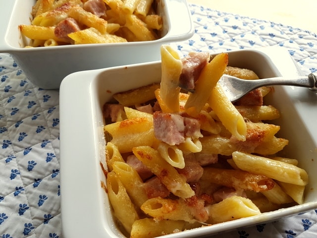 Penne pasta alla Valdostana baked in white oven dishes