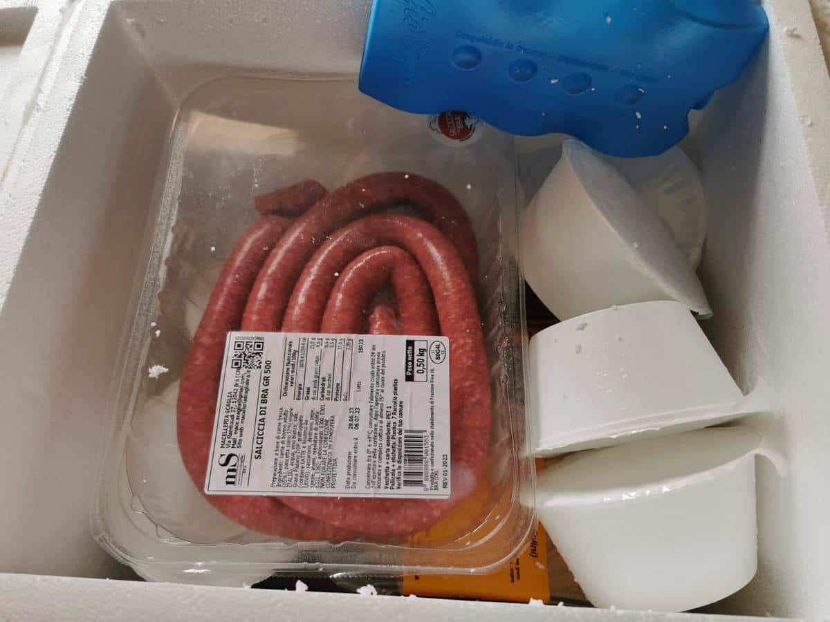 Large white styrofoam box with fresh bra sausages, tajarin and Arneis wine inside.