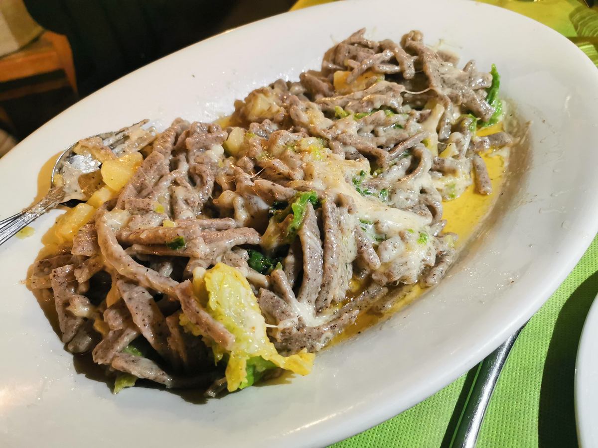 Pizzoccheri alla Valtellinese served in a restaurant in the Valtellina.