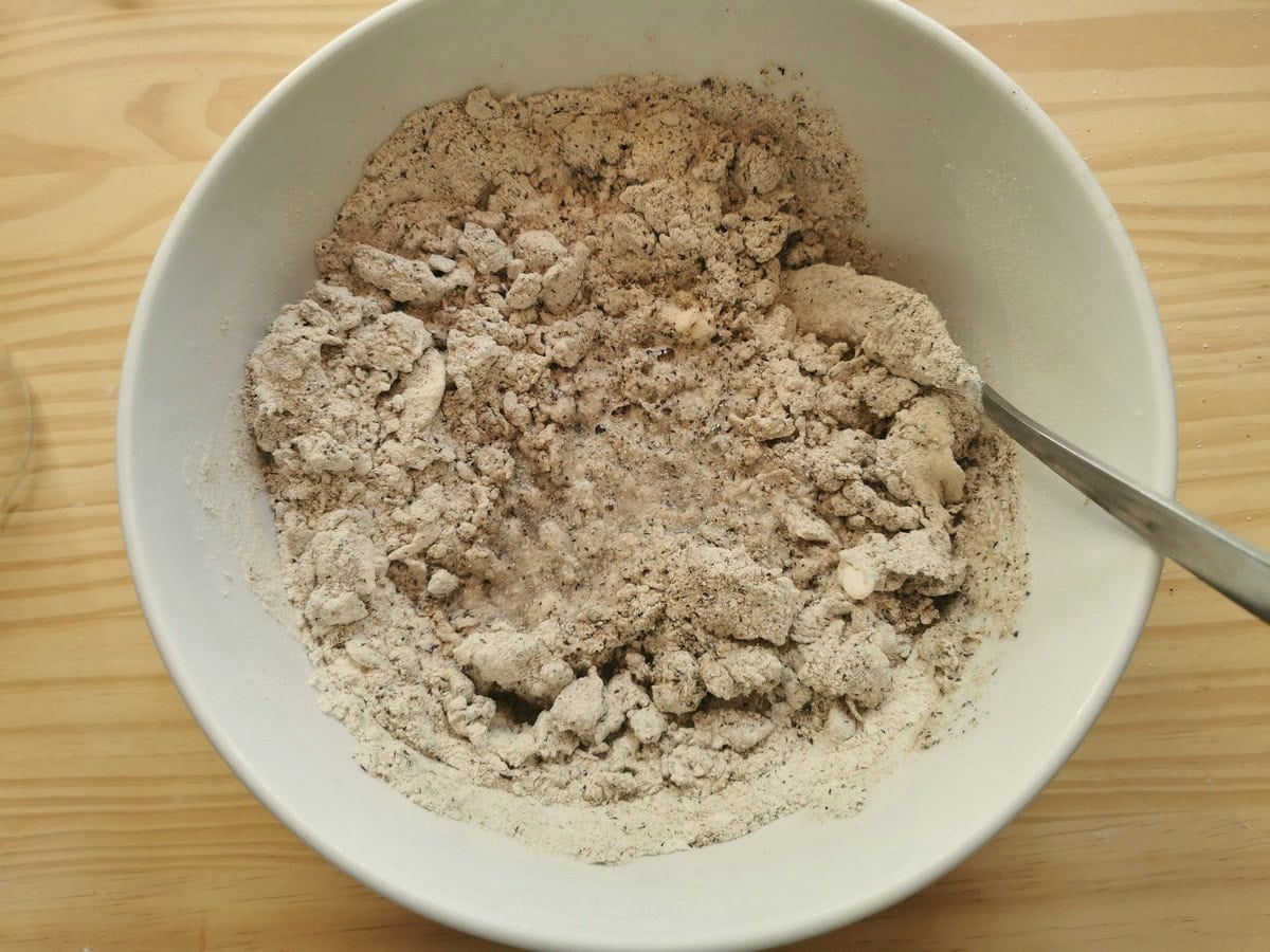 Mixed buckwheat flour and soft wheat flour mixed together with water in a large bowl.