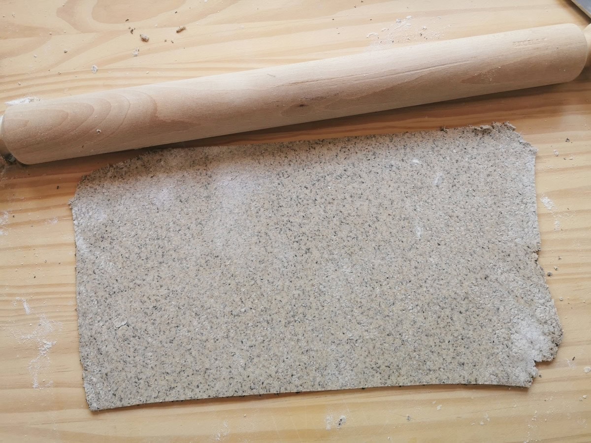 A rolled out rectangular sheet of buckwheat pasta dough.