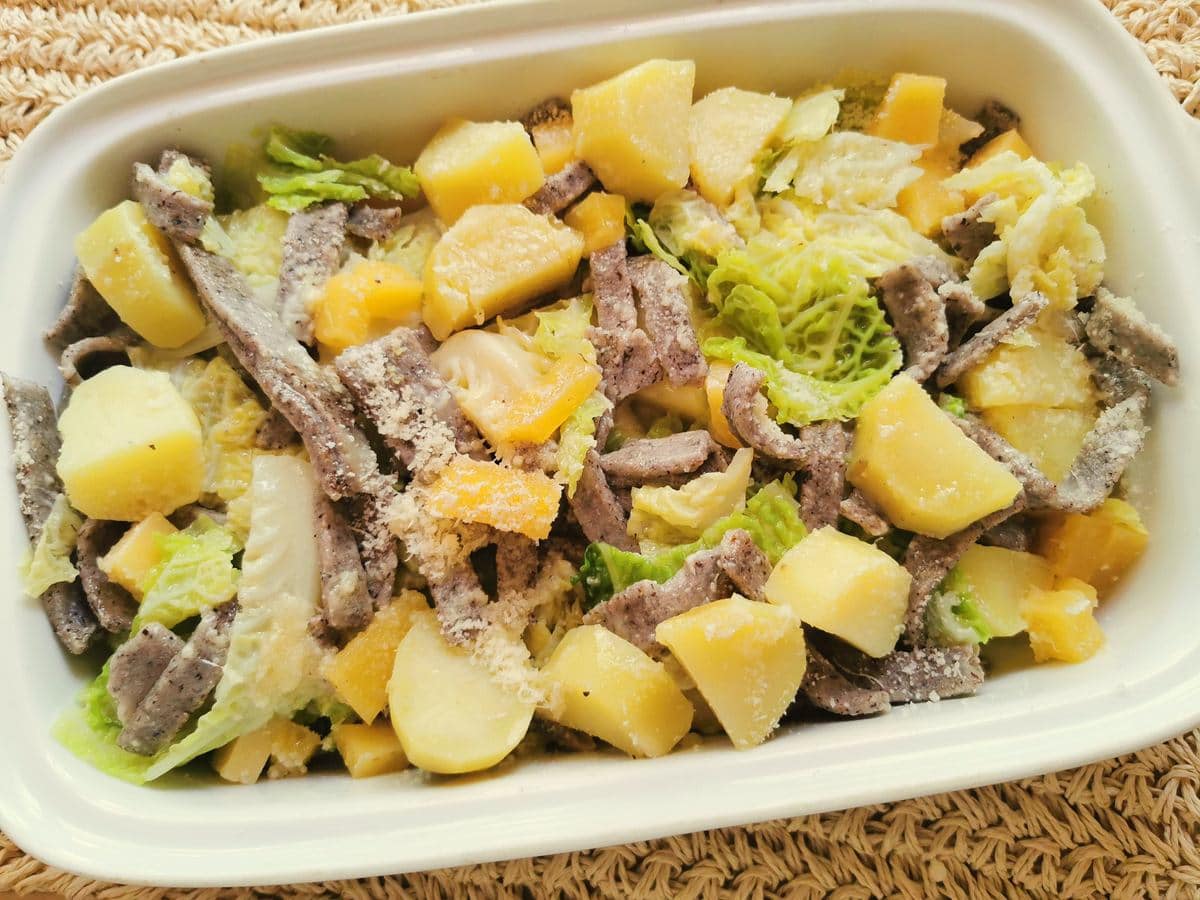 Pizzoccheri alla Valtellinese in white ceramic dish.